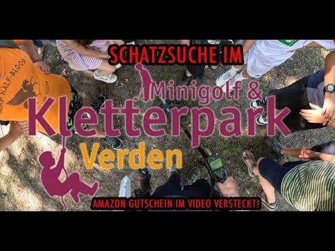 Eine Gruppe von Menschen steht im Kreis um den Schriftzug Schatzsuche im Minigolf & Kletterpark Verden, eine verspielte Grafik, die auf einen verlorenen Ring hinweist. Unterer Text: Amazon Gutschein im Video versteckt!.