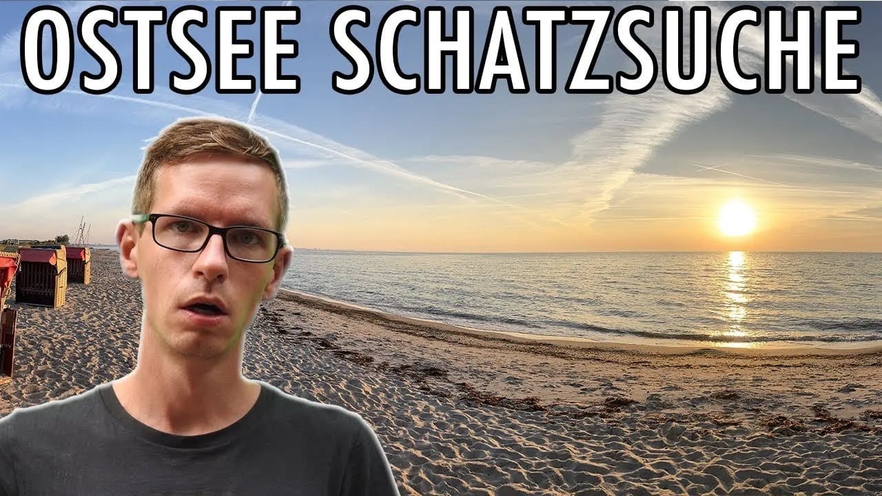 Ein Mann mit Brille steht bei Sonnenuntergang an einem Sandstrand, hinter ihm das ruhige Meer. Wolken und Kondensstreifen füllen den Himmel. Großer Text oben: OSTSEE SCHATZSUCHE-perfekt für eine Schatzsuche mit Metalldetektor.