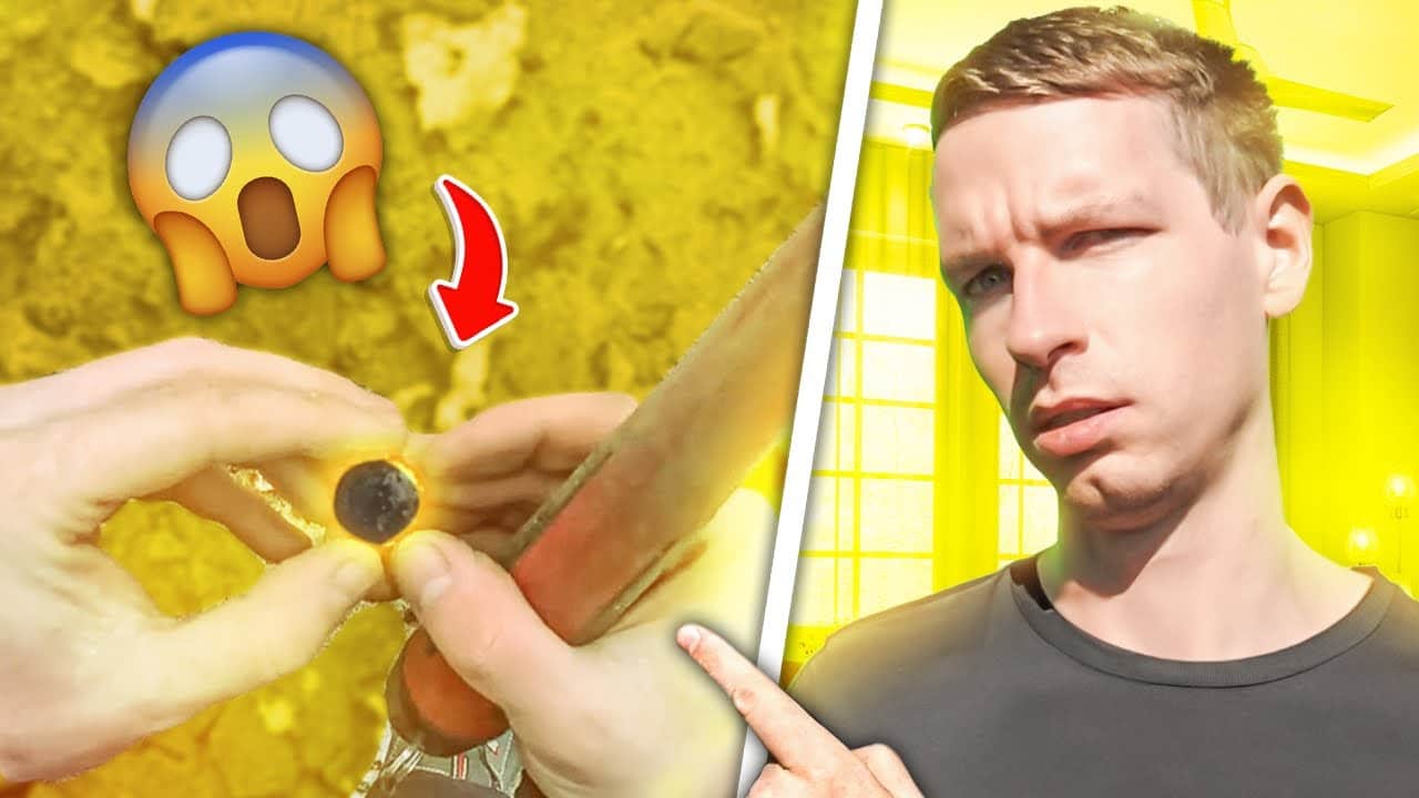 Ein Emoji mit einem überraschten Gesicht und ein roter Pfeil zeigen auf Hände im Dreck, die einen kleinen, runden Gegenstand halten - vielleicht einen "Ring verloren gefunden". Auf der rechten Seite zeigt ein verwirrter Mann in Schwarz auf die Szene, die in leuchtendem Gelb gehalten ist.