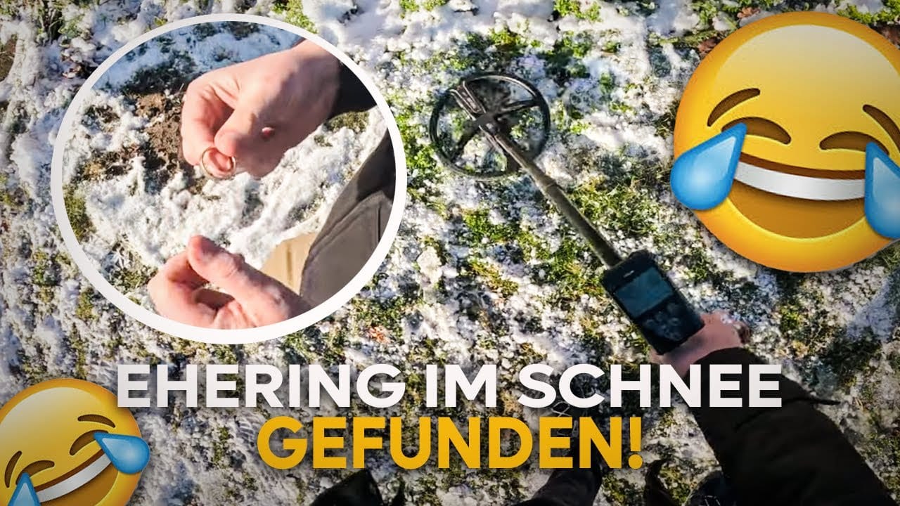Eine Person benutzt einen Metalldetektor auf verschneitem Gras während einer Schatzsuche metalldetektor und findet einen Goldring, gezeigt in Nahaufnahme. Der Text lautet Ehering im Schnee gefunden! mit lachenden Gesichtsemojis.